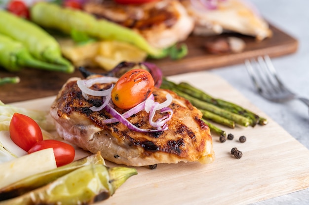 Bistecca di pollo disposta su un vassoio di legno.