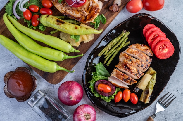 Bistecca di pollo messa su un piatto nero.