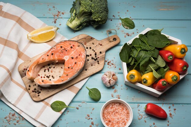 Bistecca di salmone vista dall'alto su tavola di legno con ingredienti