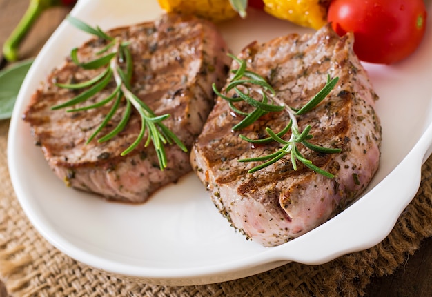 Bistecca di vitello tenera e succosa mediamente rara con patatine fritte