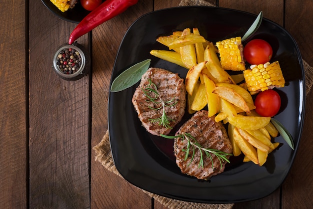 Bistecca di vitello tenera e succosa mediamente rara con patatine fritte