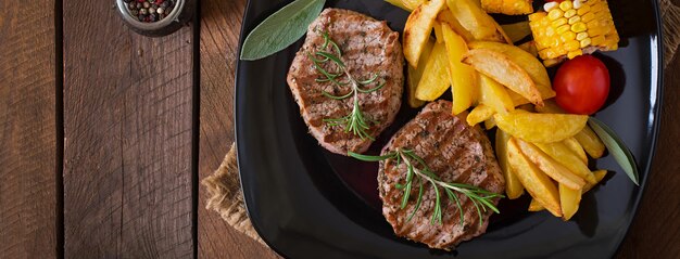 Bistecca di vitello tenera e succosa mediamente rara con patatine fritte