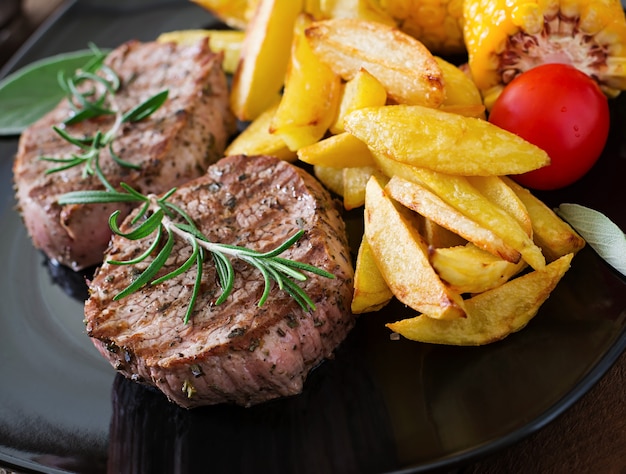 Bistecca di vitello tenera e succosa mediamente rara con patatine fritte