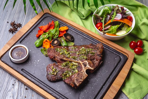 Bistecca vista dall'alto con verdure grigliate e salsa