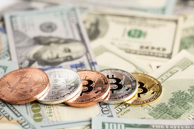 Bitcoin in vari colori in cima alle banconote da un dollaro