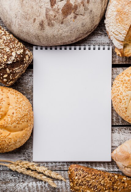 Blocco note vuoto circondato dalla disposizione di pane