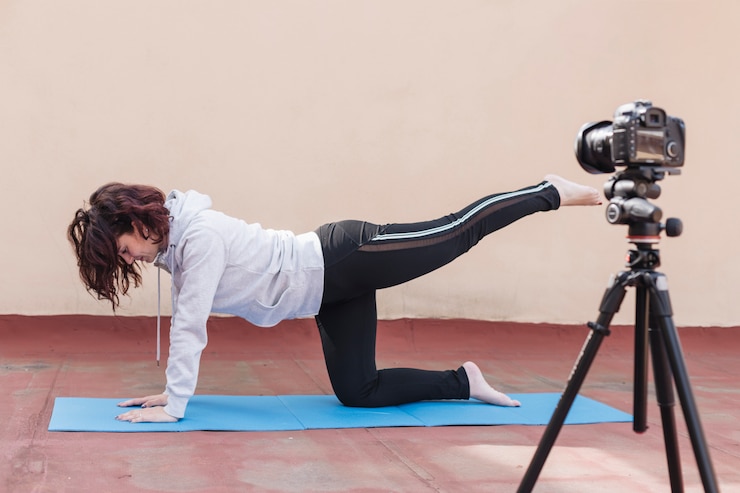 Foto gratuito blogger bruna che registra la routine di yoga