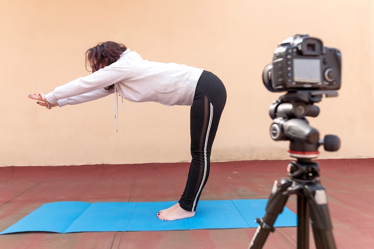 Foto gratuito blogger bruna che registra la routine di yoga
