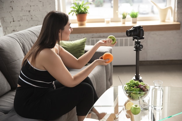 Blogger caucasica, la donna fa vlog come fare una dieta e perdere peso, essere positiva per il corpo, mangiare sano. Usando la videocamera che registra le sue ricette organiche e gustose.