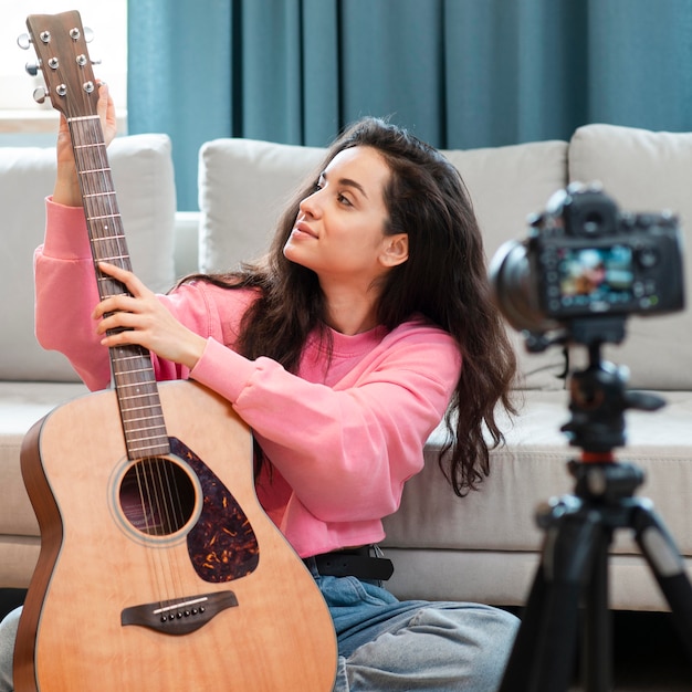 Blogger che mostra la sua chitarra spagnola alla macchina fotografica
