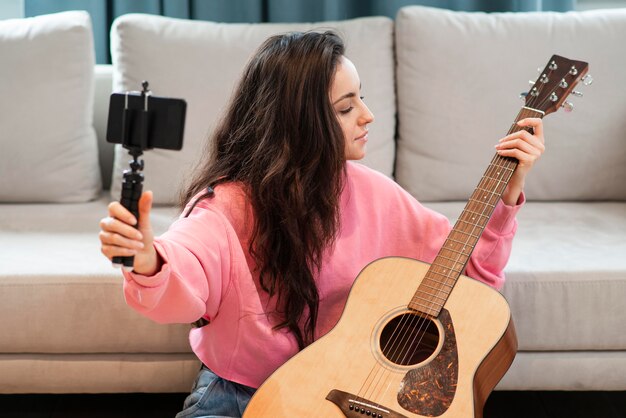 Blogger che registra con lo smartphone la sua chitarra