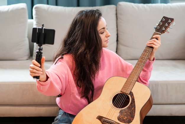 Blogger che registra con lo smartphone la sua chitarra