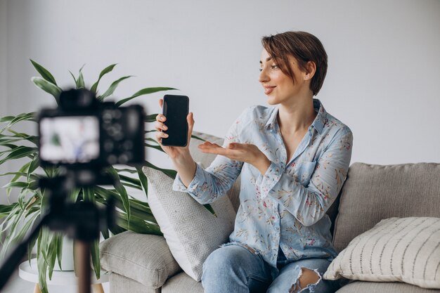 Blogger di giovane donna che registra video sulla fotocamera