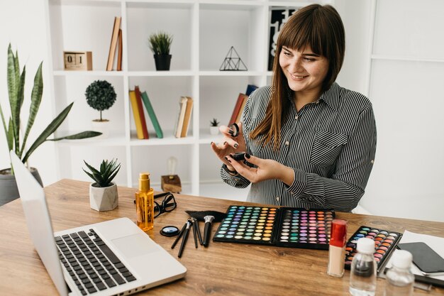 Blogger di trucco femminile con streaming con laptop