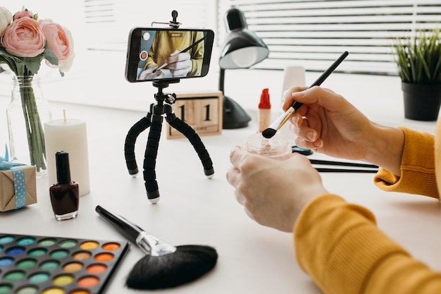 Blogger femminile in streaming make-up online con lo smartphone