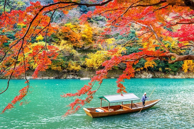 Boatman punting la barca al fiume. Arashiyama nella stagione autunnale lungo il fiume a Kyoto, in Giappone.