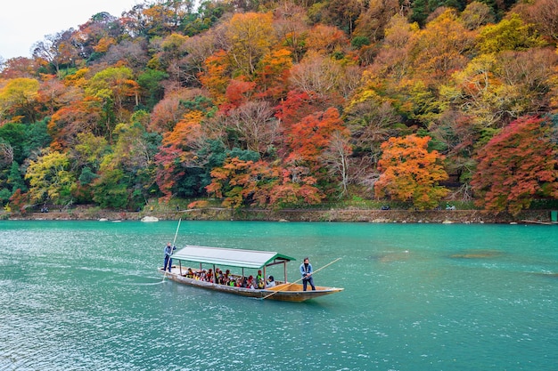 Boatman punting la barca al fiume. Arashiyama nella stagione autunnale lungo il fiume a Kyoto, in Giappone.