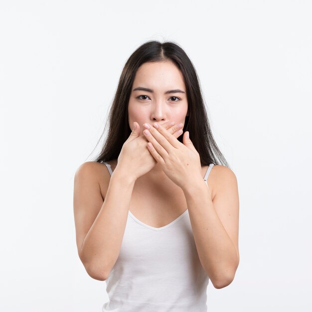 Bocca della copertura della donna di vista frontale con le mani