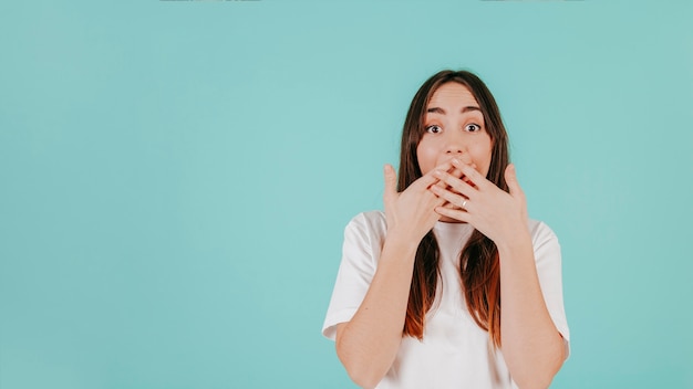 Bocca della copertura della donna sorpresa con le mani