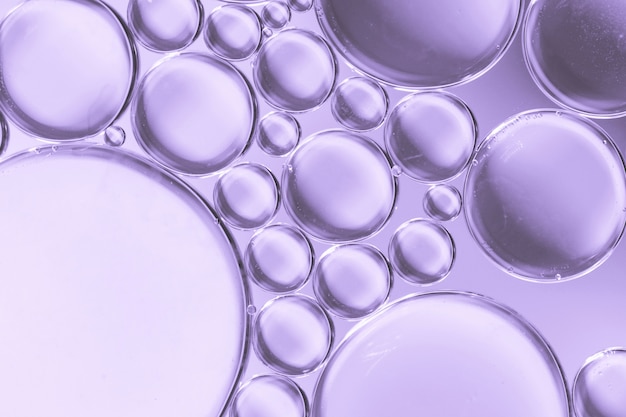 Bolle di aria astratte in liquido su sfondo colorato lilla