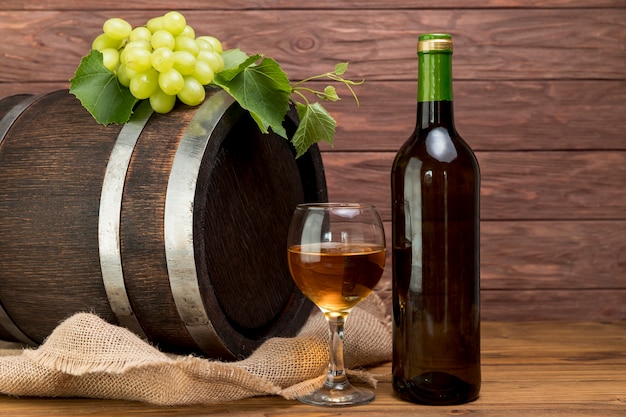 Botte di legno con bottiglia e bicchiere di vino