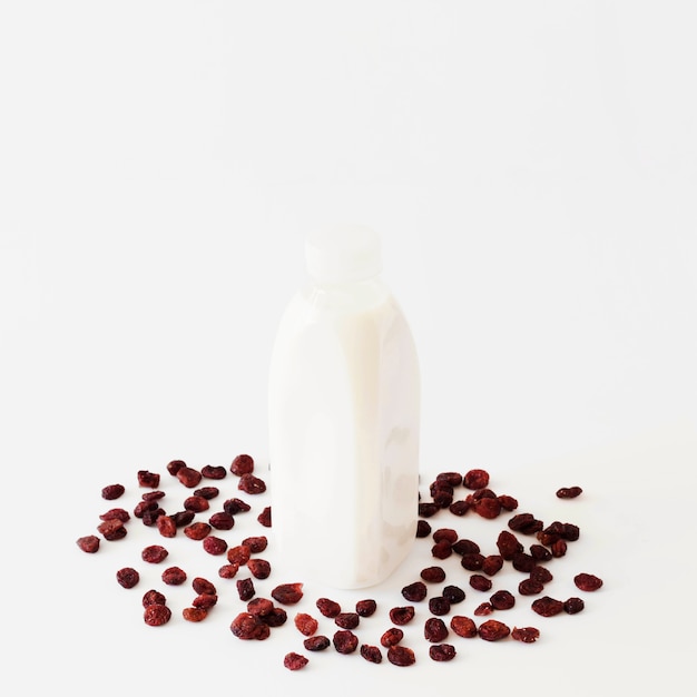 Bottiglia con liquido bianco tra frutta secca