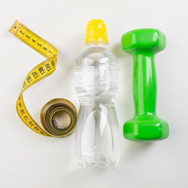 Bottiglia d'acqua e centimetro giallo e pesi