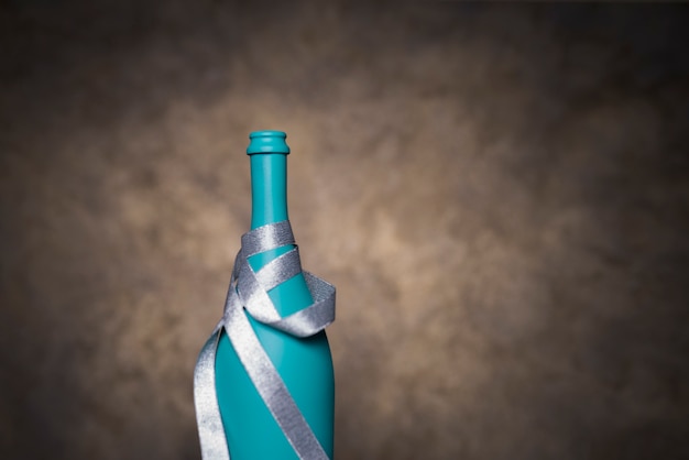 Bottiglia decorativa turchese avvolta con nastro d&#39;argento