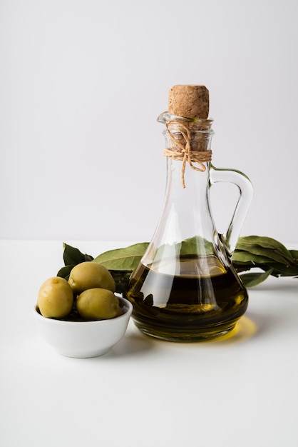 Bottiglia del primo piano di olio d'oliva e di olive biologici