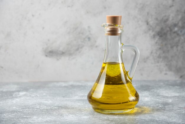 Bottiglia di olio d'oliva sul tavolo di marmo.