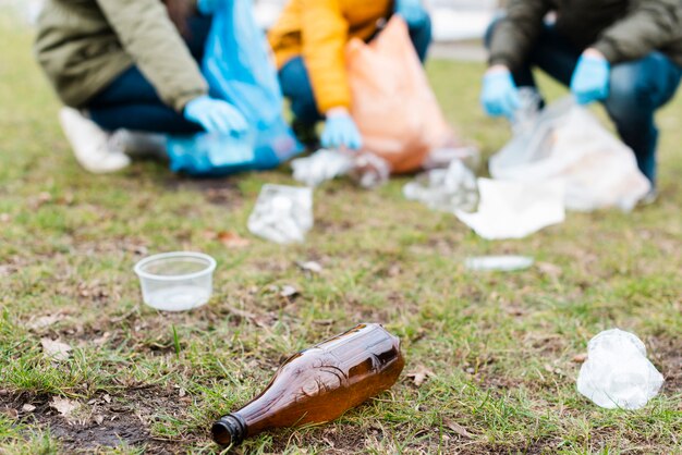 Bottiglia di plastica a terra con bambini sfocati