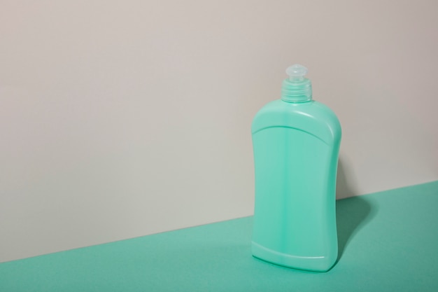 Bottiglia di plastica verde ad alto angolo con spazio per la copia