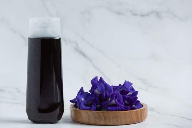 Bottiglia di shampoo di Butterfly Pea Flower messa su sfondo bianco marmo