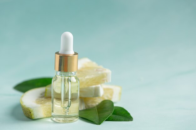 Bottiglia di siero olio di pompelmo messa su sfondo verde chiaro