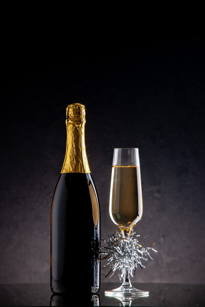 Bottiglia di vetro di champagne vista frontale su superficie scura