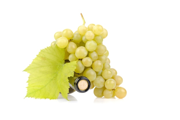 Bottiglia di vino bianco ed uva isolati su bianco