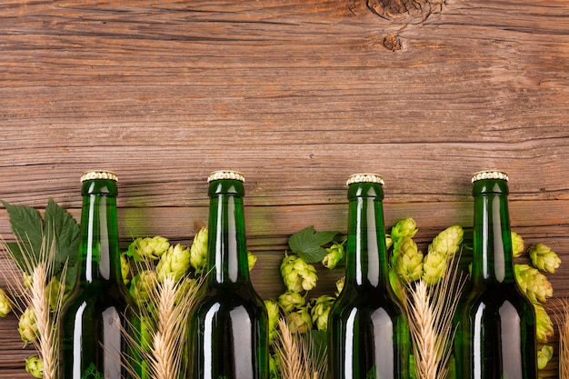 Bottiglie di birra verdi su fondo di legno