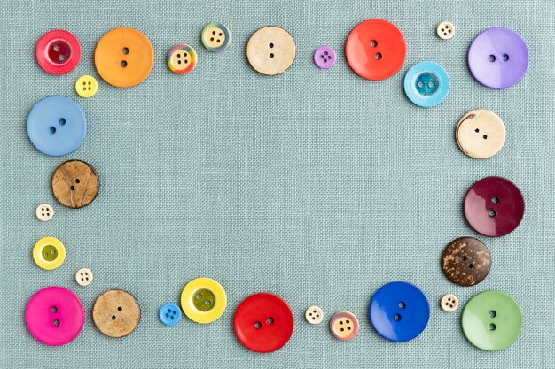 Bottoni colorati piatti laici sul panno