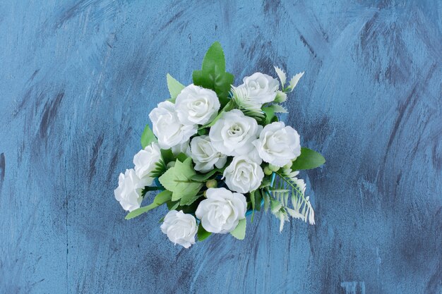 Bouquet con composizione di rose bianche naturali su blu.