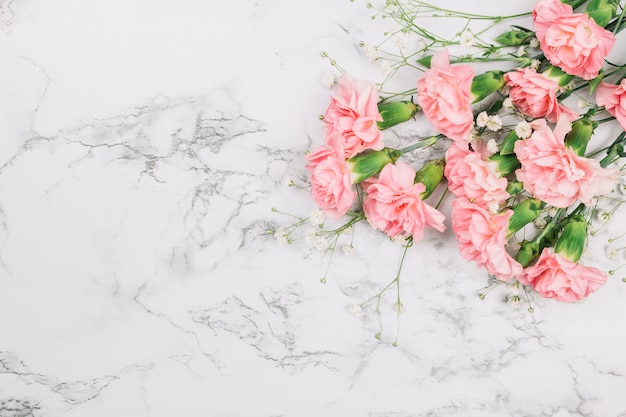 Bouquet di fiori e garofani da baby-sitter sull&#39;angolo del fondale in marmo