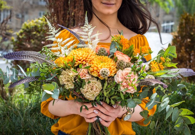 bouquet di fiori estivi nelle mani della ragazza