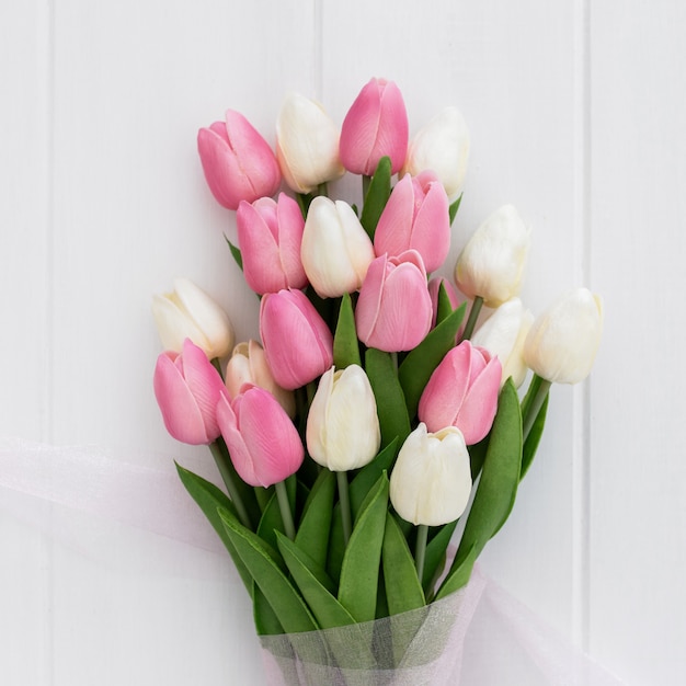 bouquet di tulipani piuttosto rosa e bianchi su fondo in legno