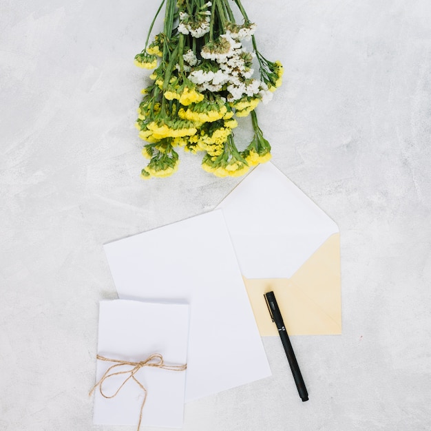 Bouquet vicino a penna e biglietti di auguri