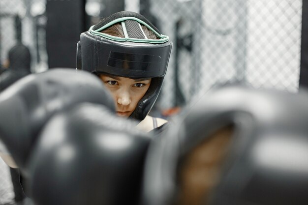 Boxe femminile. Principianti in palestra. Signora in abbigliamento sportivo nero.