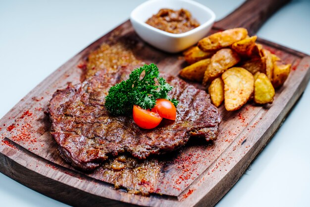 braciola di carne arrosto con patate fritte laterali