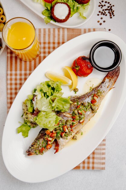 branzino alla griglia con insalata fresca e pomodori grigliati