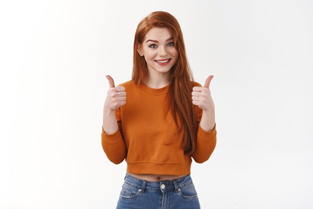 Bravo bel lavoro Soddisfatto attraente tenero elegante ragazza dai capelli rossi lungo rosso taglio di capelli mostra pollice in su approvazione grande gesto sorridente ampiamente d'accordo come scelta perfetta felice di dare una risposta soddisfacente