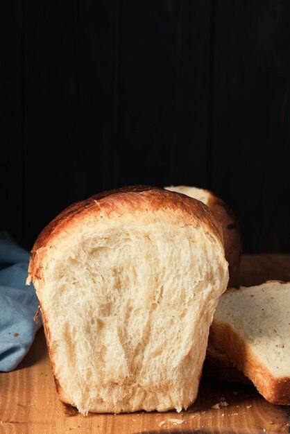 Brioche morbida spezzata a metà su una tavola di legno Concetto di brioche francese dolce tradizionale al forno Messa a fuoco selettiva del primo piano