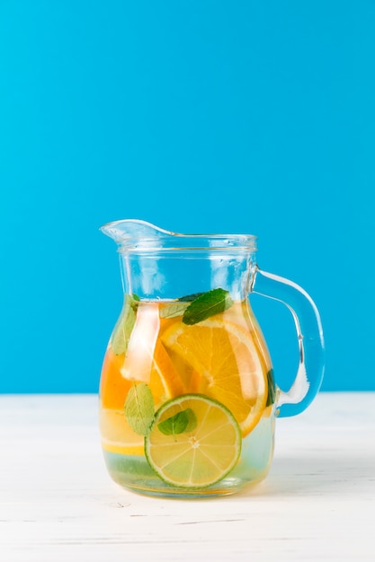 Brocca con limonata fatta in casa con sfondo blu