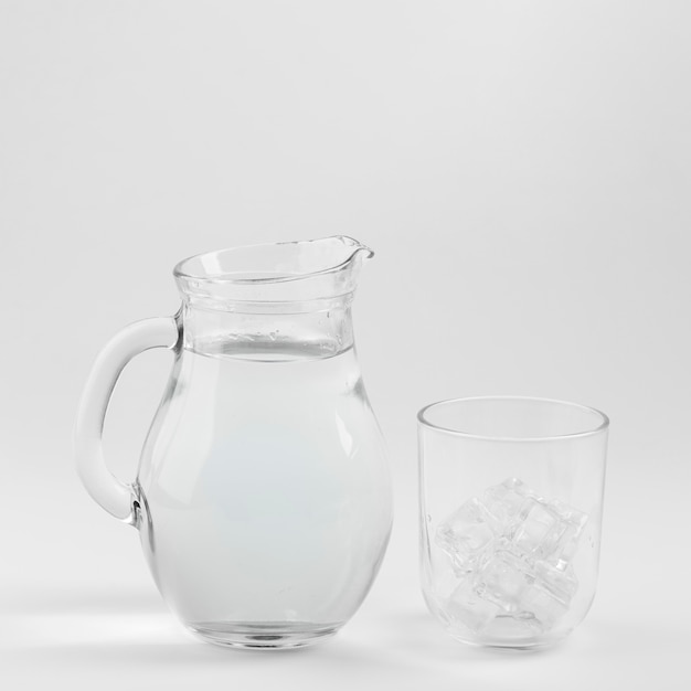 Brocca d'acqua e bicchiere riempiti di ghiaccio